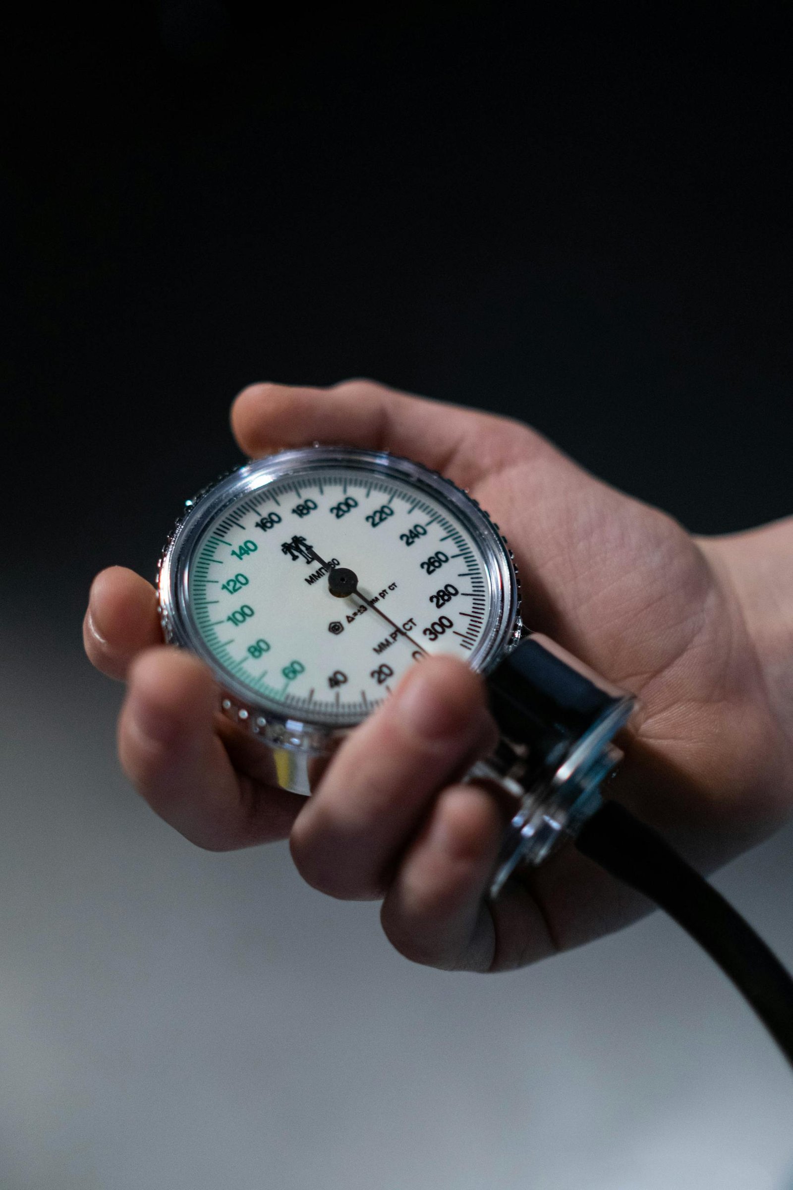 Close-Up Photo of a Person Holding a Sphygmomanometer Gauge